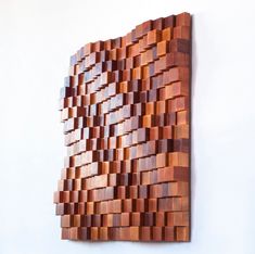 a wooden wall hanging on the side of a white wall