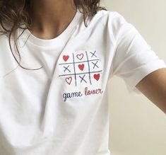 a woman wearing a white t - shirt with the word game lover printed on it