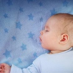 a baby laying on top of a blue blanket