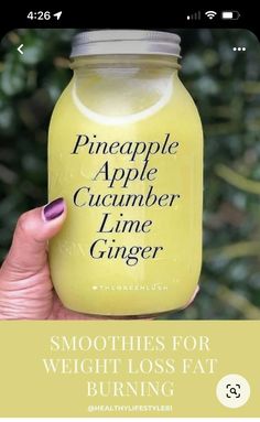 a woman holding up a jar of smoothie with the words pineapple apple cucumber lime ginger