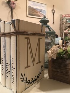 a box with the letter m on it is sitting in front of some flowers and candles