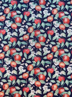 an apple print fabric with white flowers and leaves on a black background, closeup