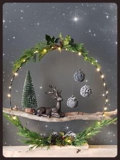 a wooden shelf with christmas decorations on top of it and lights hanging from the branches