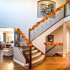 an elegant staircase decorated with fall leaves