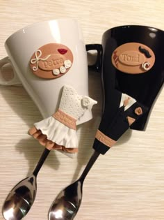 two coffee mugs with spoons on top of each one and the other is decorated