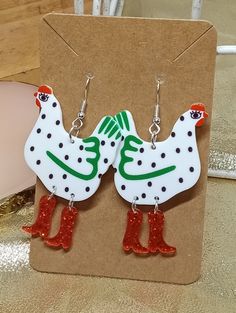 "Add a whimsical touch to your outfit with these handcrafted Chicken In Rainboots Earrings. The adorable design and high-quality materials make these earrings a unique and fun addition to any jewelry collection. Let these earrings brighten up your day and spark joy in those around you!" Whimsical Red Drop Earrings, Novelty Red Pierced Earrings, Whimsical Red Nickel-free Earrings, Red Whimsical Nickel-free Earrings, Whimsical Handmade Red Earrings, Quirky Handmade Multicolor Earrings, Quirky Multicolor Handmade Earrings, Fun Red Adjustable Earrings, Cute Handmade Christmas Earrings