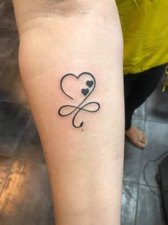 a small tattoo on the arm of a woman with two hearts and an infinite sign