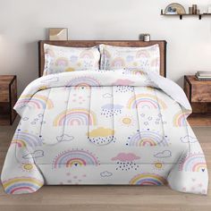 a bed with rainbows, clouds and stars on it in a white room next to two nightstands