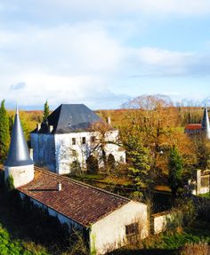 an aerial view of some old buildings in the country side with trees and bushes around them