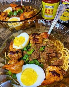 two bowls filled with noodles, meat and eggs