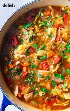 a pot filled with soup and vegetables on top of a table