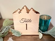 a wooden table number with a candle on it