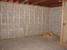 an unfinished room with concrete walls and wood framing on the wall is being built in order to make it look like new construction