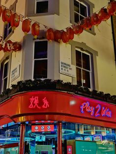 the front of a chinese restaurant with lanterns hanging from it's roof and windows