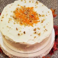 a three layer cake with white frosting and orange toppings