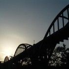 the sun is setting over an old bridge