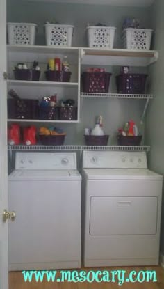 a washer and dryer sitting in a room next to each other with baskets on the shelves