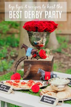 a table topped with plates and cups filled with food next to a vase full of roses