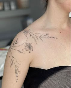 a woman with a flower tattoo on her chest and shoulder is looking at the camera