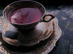 a cup of tea on a saucer next to a plate with a cell phone