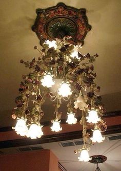 a chandelier hanging from the ceiling in a room with an ornate light fixture