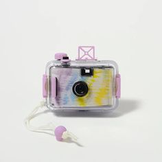 a small camera sitting on top of a white table next to headphones and a string