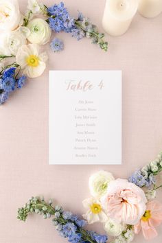 a table with flowers and candles next to a card that says table 4 on it