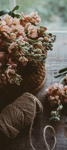 flowers and twine on a table next to a window