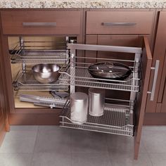 an open cabinet in a kitchen with pots and pans on the bottom shelf,