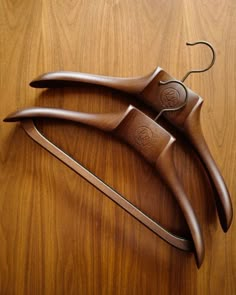 two wooden hangers sitting on top of a wooden table