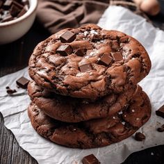 three chocolate cookies stacked on top of each other with chunks of chocolate in the middle