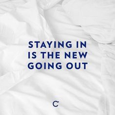 an unmade bed with the words staying in is the new going out