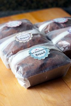 four bags of brownies sitting on top of a wooden table