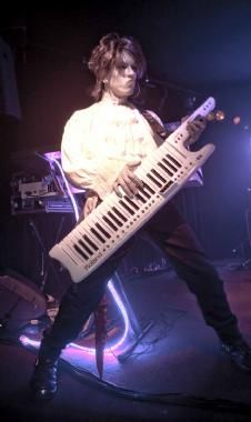 a man holding an electronic keyboard on stage