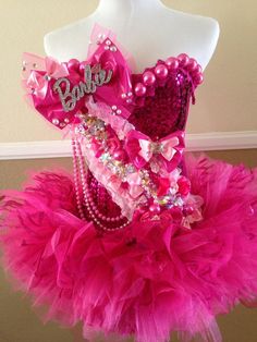 a mannequin wearing a pink dress with pearls and beads