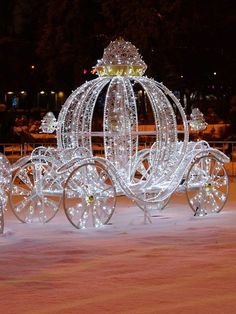 a horse drawn carriage covered in lights at night