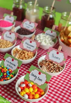 a table topped with bowls filled with different types of candies and candy bar signs