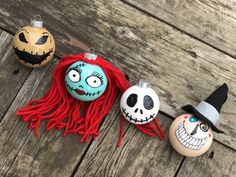 three halloween ornaments are sitting on a wooden table