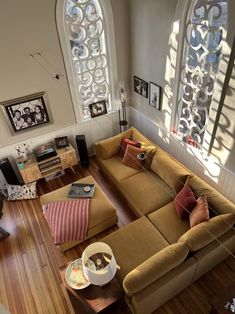 an aerial view of a living room with couches, windows and pictures on the wall