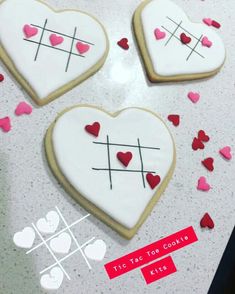 three decorated heart shaped cookies with crosses and hearts scattered around them on a counter top