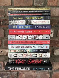 a stack of books sitting on top of a brick wall