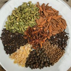 a white plate topped with lots of different types of spices on top of each other