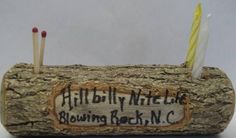 a wooden log with candles in it that says hillbilly mitchell blowing rock nc