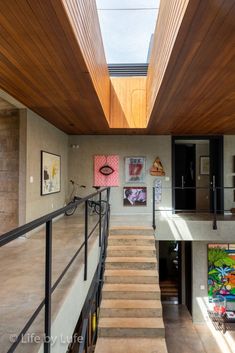 a staircase leading to the upper level of a house with wood paneling on the ceiling