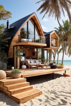 a house on the beach with stairs leading up to it and palm trees in the background