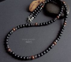 Necklace with matte black onyx beads, beautifully grained Mundambi wood beads and dark silver hematite discs. The bead diameter is 6 mm. Strung on a sturdy coated stainless steel wire with a stainless steel carabiner clasp Handcrafted Men’s Necklaces, Mens Wood Bead Necklace, Men's Black Beaded Necklace, Onyx Necklace Men, Pearl Necklace Men, Luxury Onyx Beaded Necklace, Onyx Bead, Men's Necklace, Men Necklace