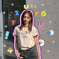 a girl standing in front of a wall with letters on it