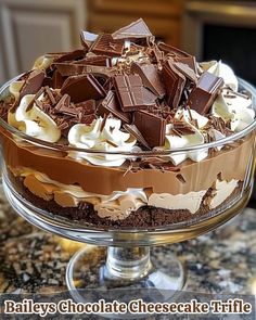 there is a cake with chocolate and whipped cream on top in the glass dish that says bailey's chocolate cheesecake trifle