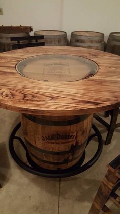 a table made out of wine barrels with a glass top