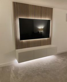 a television mounted on the side of a wall in a room with carpeted flooring